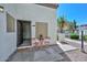 Condo's exterior with a red bistro set, welcome mat, and open door at 4730 W Northern Ave # 1141, Glendale, AZ 85301