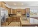 Spacious kitchen featuring wooden cabinets, granite countertops, stainless steel appliances and tiled floors at 5330 S Big Horn Pl, Chandler, AZ 85249