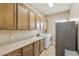 An organized laundry room featuring sink, cabinets, and modern appliances at 5330 S Big Horn Pl, Chandler, AZ 85249