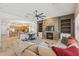 Open concept living room with fireplace, stone surround, ceiling fan and access to kitchen at 5330 S Big Horn Pl, Chandler, AZ 85249