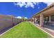 Lush backyard with a well-maintained lawn, covered patio, and serene landscaping, ideal for outdoor enjoyment at 5635 W Pecan Rd, Laveen, AZ 85339