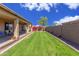 Expansive backyard featuring a verdant lawn, charming garden beds, and a covered patio for outdoor living at 5635 W Pecan Rd, Laveen, AZ 85339