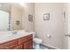 A well-lit bathroom featuring a cherry wood vanity with a white sink and neutral wall paint and tile flooring at 5635 W Pecan Rd, Laveen, AZ 85339