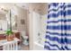 This bathroom features a shower with a blue striped curtain, cherry wood vanity, and neutral wall paint at 5635 W Pecan Rd, Laveen, AZ 85339