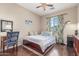 This bedroom includes a wood-framed bed, hardwood floors, neutral walls and floral curtains framing the window at 5635 W Pecan Rd, Laveen, AZ 85339