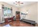 This versatile room features a treadmill, hardwood floors, and a window with curtains for privacy and natural light at 5635 W Pecan Rd, Laveen, AZ 85339