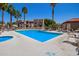 Community pool surrounded by palm trees at 5757 W Eugie Ave # 2084, Glendale, AZ 85304