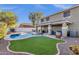 Inviting backyard features a sparkling pool, lush green lawn, and covered patio, perfect for outdoor relaxation and entertaining at 5919 S Banning St, Gilbert, AZ 85298