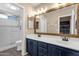 Bathroom with double sink vanity, framed mirror and shower with glass door at 5919 S Banning St, Gilbert, AZ 85298