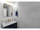 Modern powder room featuring a navy vanity with a white marble countertop and gold hardware at 5919 S Banning St, Gilbert, AZ 85298