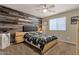 Bedroom with wood accent wall, neutral carpet, ceiling fan, and black and white bedding at 5919 S Banning St, Gilbert, AZ 85298