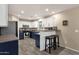 Open concept kitchen with stainless appliances, white cabinets, breakfast bar, and modern lighting at 5919 S Banning St, Gilbert, AZ 85298