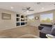 Bright living room with built-in shelves, a comfortable gray sofa and large windows at 5919 S Banning St, Gilbert, AZ 85298