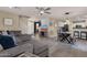 Open-concept living room featuring wood-look flooring, a view of the dining area, and lots of natural light at 5919 S Banning St, Gilbert, AZ 85298