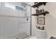 Bright shower with glass doors, white tile, and wall shelving at 5919 S Banning St, Gilbert, AZ 85298