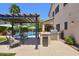 Backyard featuring a pool, covered pergola, outdoor kitchen and barbecue, and outdoor seating area at 6570 S Pewter Way, Chandler, AZ 85249