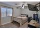 Neutral bedroom featuring a ceiling fan, laminate floors, window and a wall-mounted TV at 6570 S Pewter Way, Chandler, AZ 85249