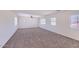 Spacious bedroom with neutral carpet, multiple windows for natural light, and a ceiling fan at 6570 S Pewter Way, Chandler, AZ 85249