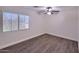 Bright bedroom features a ceiling fan, wood-look floors, and a window for natural light at 6570 S Pewter Way, Chandler, AZ 85249