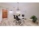 Well-lit dining area featuring modern chandelier, sleek table, and tile flooring for a stylish meal setting at 6570 S Pewter Way, Chandler, AZ 85249