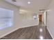 Spacious hallway features laminate flooring, window and white walls, leading to several rooms at 6570 S Pewter Way, Chandler, AZ 85249