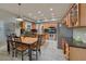 Traditional kitchen with wooden cabinets, stainless steel appliances, tile flooring, recessed lighting, and dining table at 6570 S Pewter Way, Chandler, AZ 85249