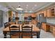 Well-lit kitchen features stainless steel appliances, wooden cabinets, granite countertops, and an adjacent dining area at 6570 S Pewter Way, Chandler, AZ 85249