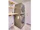 Laundry room features a stacked washer and dryer, tiled floors and open shelving at 6570 S Pewter Way, Chandler, AZ 85249