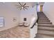 Bright living room featuring high ceilings, tile floors, and a staircase leading to the upper level at 6570 S Pewter Way, Chandler, AZ 85249