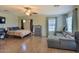 Spacious open floorplan with light laminate floors, ceiling fan, and a modern gray sofa and furniture at 6570 S Pewter Way, Chandler, AZ 85249