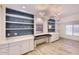 Home office with built-in shelving, cabinets, desk space, and stylish lighting fixtures at 6570 S Pewter Way, Chandler, AZ 85249