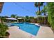 Inviting backyard pool with mature landscaping, lounge area, and tranquil waterfall feature at 6570 S Pewter Way, Chandler, AZ 85249