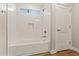 Clean, white bathroom featuring a tub with white tiled walls and wood-look floors at 6843 S 46Th Dr, Laveen, AZ 85339
