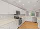 Modern kitchen with white cabinets, stainless steel appliances, and quartz countertops at 6843 S 46Th Dr, Laveen, AZ 85339