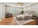 Spacious main bedroom featuring wood flooring, neutral colors, natural light, and an accent chair at 6843 S 46Th Dr, Laveen, AZ 85339