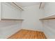 Spacious walk-in closet with wood-look floors and wooden shelving at 6843 S 46Th Dr, Laveen, AZ 85339