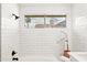 Bright white bathroom with tile surround tub, and window allowing natural light at 7108 W Corrine Dr, Peoria, AZ 85381