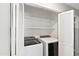 Bright laundry room with white washer and dryer, plus convenient shelving behind louvered doors at 7108 W Corrine Dr, Peoria, AZ 85381