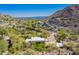High altitude shot shows this home nestled into the desert hillside, featuring a pool and surrounded by lush landscaping at 7131 N 40Th St, Paradise Valley, AZ 85253