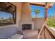 A cozy fireplace on a covered balcony with terracotta tile flooring and comfortable seating at 7131 N 40Th St, Paradise Valley, AZ 85253