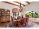Charming dining room with exposed wood beams, chandelier, and access to an outdoor area with desert views at 7131 N 40Th St, Paradise Valley, AZ 85253