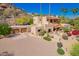 Beautiful exterior of a desert home featuring a porte cochere, terracotta roofing, mature landscaping and a circular driveway at 7131 N 40Th St, Paradise Valley, AZ 85253