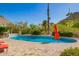 Inviting pool area with desert landscaping and an orange umbrella, perfect for relaxation and outdoor enjoyment at 7131 N 40Th St, Paradise Valley, AZ 85253