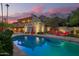 Rear exterior view of the home featuring the pool, patio with red lounge chairs, and second story balcony at 7131 N 40Th St, Paradise Valley, AZ 85253