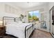 Bright bedroom featuring modern decor, plantation shutters, and a view to a beautifully landscaped yard at 7169 E Bramble Berry Ln, Scottsdale, AZ 85266