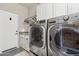 Laundry room featuring modern washer and dryer and white cabinets at 7169 E Bramble Berry Ln, Scottsdale, AZ 85266