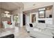 Open-concept living room with white furniture, fireplace, and neutral walls at 7169 E Bramble Berry Ln, Scottsdale, AZ 85266