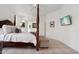 Bright main bedroom featuring a wooden four-poster bed, neutral colors, and tile flooring at 7169 E Bramble Berry Ln, Scottsdale, AZ 85266