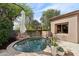 Lush landscaping surrounds a relaxing backyard pool with an umbrella and desert plants that creates a serene oasis at 7169 E Bramble Berry Ln, Scottsdale, AZ 85266
