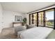 This bright bedroom features neutral colors, a sitting area and sliding glass door to a balcony at 7175 E Camelback Rd # 510, Scottsdale, AZ 85251